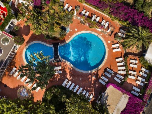 an overhead view of a swimming pool with chairs and palm trees at Grand Hotel Il Moresco in Ischia