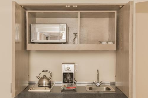 a kitchen with a sink and a microwave at Suites Contempo in Mexico City