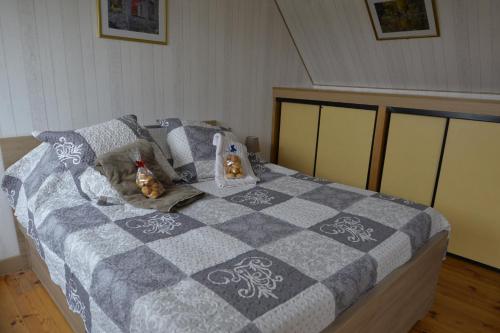 a bedroom with a bed with a gray and white quilt at Couloumine Breizh in Saint-Aignan