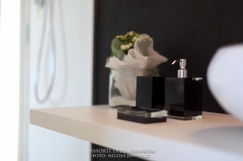 a bathroom shelf with a soap dispenser and a plant at Horti Della Fasanara in Ferrara