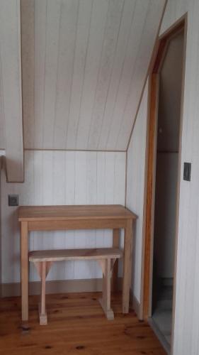 a wooden bench sitting in the corner of a room at Couloumine Breizh in Saint-Aignan