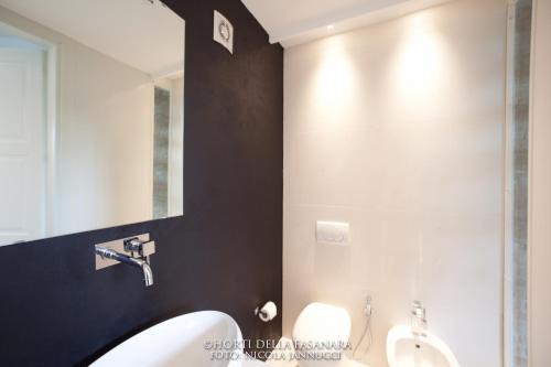 a bathroom with two toilets and a sink and a mirror at Horti Della Fasanara in Ferrara