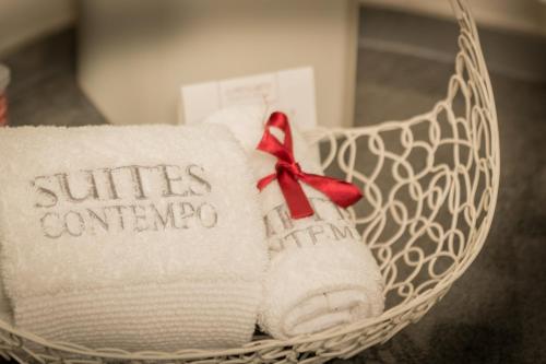 a white basket with towels with a red bow at Suites Contempo in Mexico City