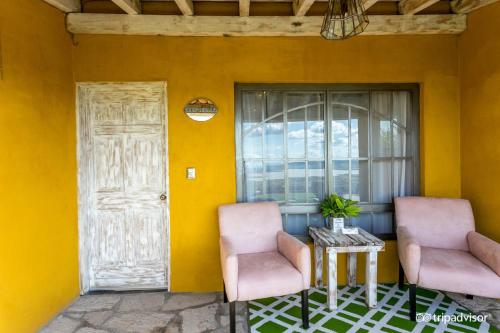 two chairs and a table in front of a yellow wall at View Hotel Boutique in San Miguel de Allende