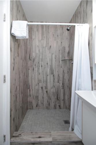 a bathroom with a shower with a wooden wall at The Dolphin Hollywood in Hollywood