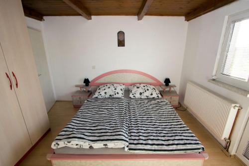 a bedroom with a bed with a striped blanket on it at Holiday Home Janko in Bogojina