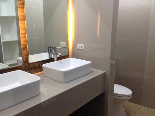 a bathroom with two sinks and a toilet and a mirror at Zacona Eco-Resort & Biblical Garden in Santa Monica