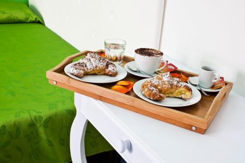 a tray with three pastries and coffee on a bed at Blu Mediterraneo B&B in Messina