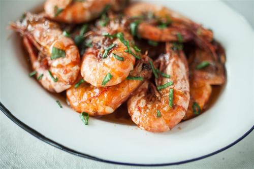 a plate of shrimp with sauce on a white plate at Natura Vista in Panglao
