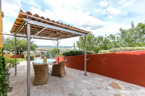 a patio with a table and chairs under a pergola at View Hotel Boutique in San Miguel de Allende