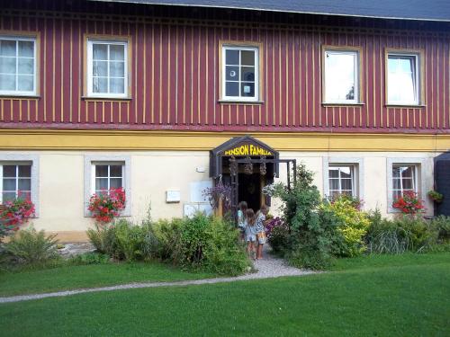 two children standing in the doorway of a building at Pension Familia in Harrachov