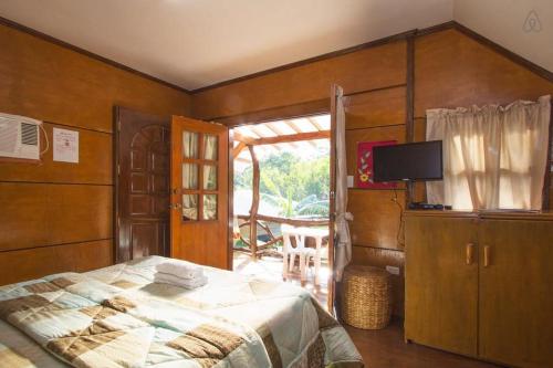 a bedroom with a bed and a television in it at Natura Vista in Panglao