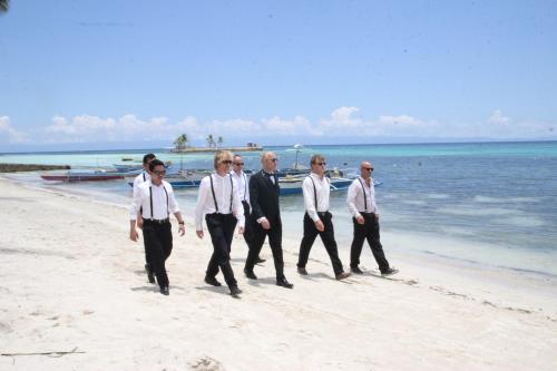 a group of men walking on the beach at Natura Vista in Panglao
