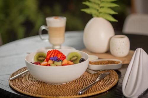 a bowl of fruit on a table with a drink at Suites Contempo in Mexico City