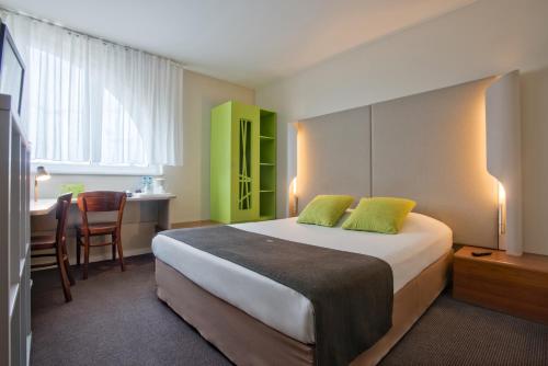 a hotel room with a bed and a desk and a kitchen at Campanile Łódź in Łódź