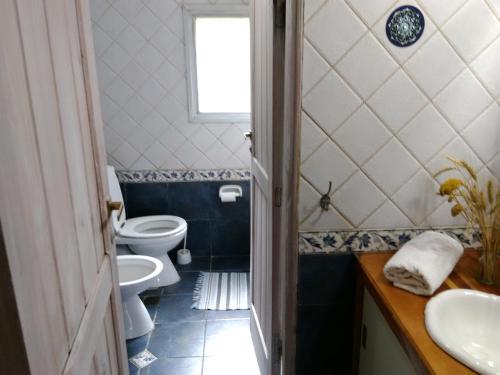 baño con 2 aseos, lavamanos y ventana en Albatros cabaña en Villa La Angostura