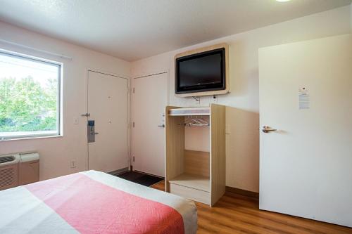 a bedroom with a bed and a tv on the wall at Motel 6-Prescott, AZ in Prescott
