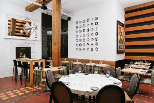 a dining room with tables and chairs and a fireplace at Moda Hotel in Vancouver