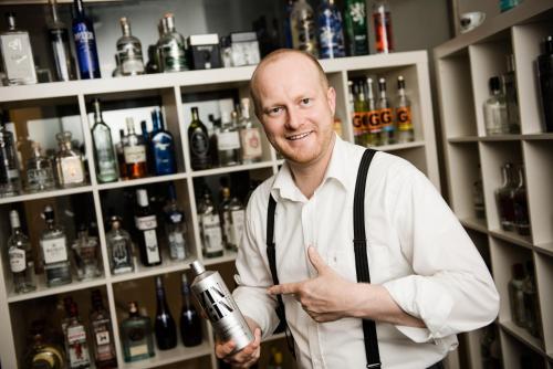 a man standing in a bar holding a bottle of alcohol at Hotel Liebmann in Lassnitzhöhe