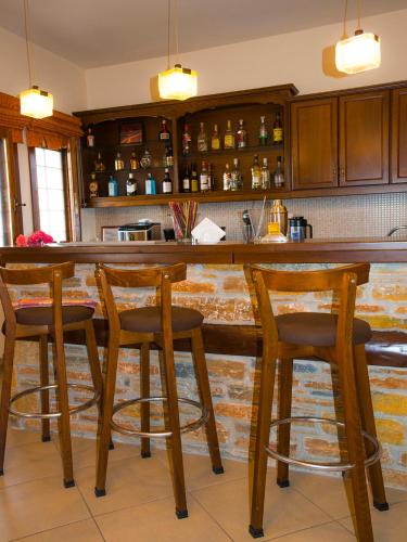 a kitchen with a wooden bar with three stools at Mirtillo Apartments in Kissós
