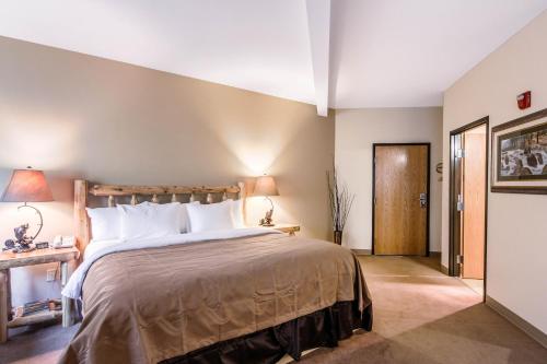 a bedroom with a large bed with a wooden headboard at Quality Inn Selah North Park in Selah
