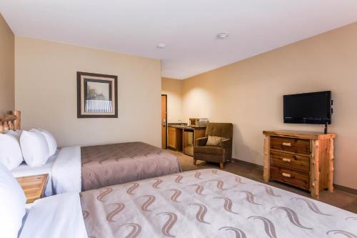 a hotel room with two beds and a flat screen tv at Quality Inn Selah North Park in Selah