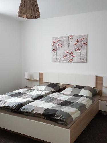 1 cama en un dormitorio con una pintura en la pared en Gemütliche Ferienwohnung, Ländlich und Stadtnah, ruhig gelegen, en Rheda-Wiedenbrück