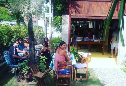 a group of people sitting in chairs outside a restaurant at Pousada Liras da Poesia in Porto De Galinhas