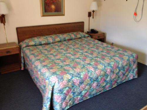 a bed with a colorful comforter in a hotel room at Greencastle Inn in Greencastle
