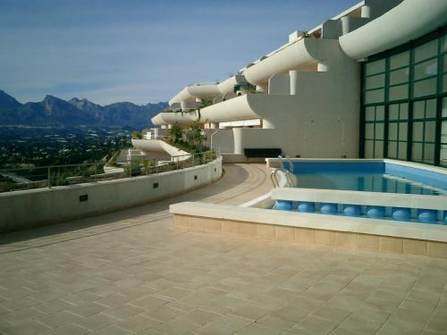 アルテアにあるÁtico soleado con terraza, jacuzzi privado y vistas al marのスイミングプール付きの建物