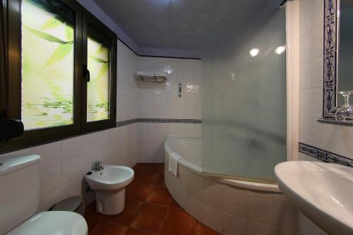 y baño con bañera, aseo y lavamanos. en Hotel Rural Ocell Francolí, en Espluga de Francolí