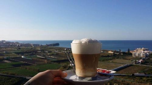 Hotel Salambina في سالوبرينيا: شخص يحمل فنجان قهوة على صحن