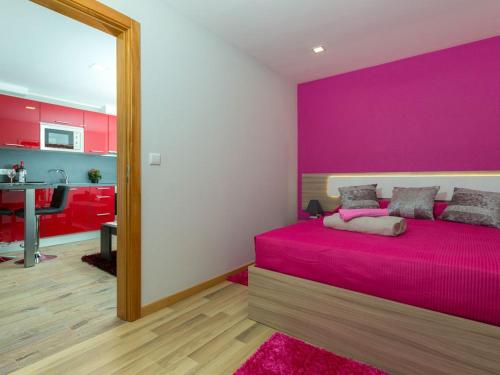 Dormitorio rosa con cama con pared de color rosa en Casa Silva en Calheta