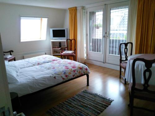 een slaapkamer met een bed en een glazen schuifdeur bij Anna's B&B Rijssen in Rijssen