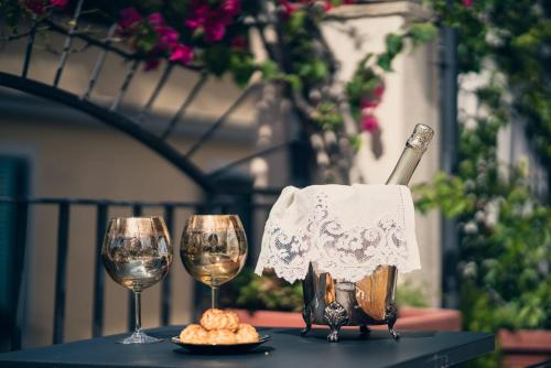 einen Tisch mit zwei Gläsern Wein und einem Teller Essen in der Unterkunft Il Covo B&B in Rom