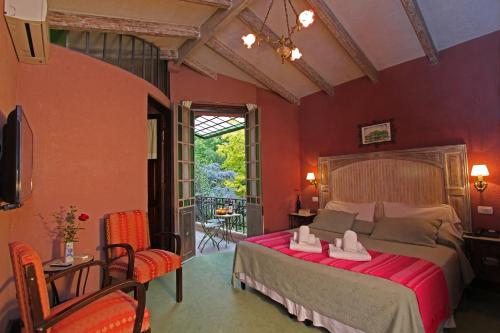 a bedroom with a large bed with red walls at Casa Glebinias in Chacras de Coria