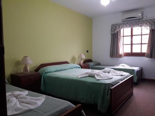 ein Hotelzimmer mit zwei Betten mit Handtüchern darauf in der Unterkunft Hotel La Maison in La Lucila del Mar