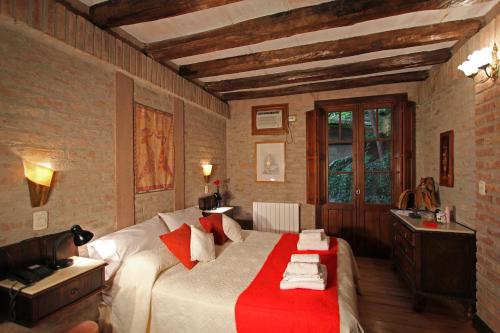 a bedroom with a bed with a red blanket on it at Casa Glebinias in Chacras de Coria