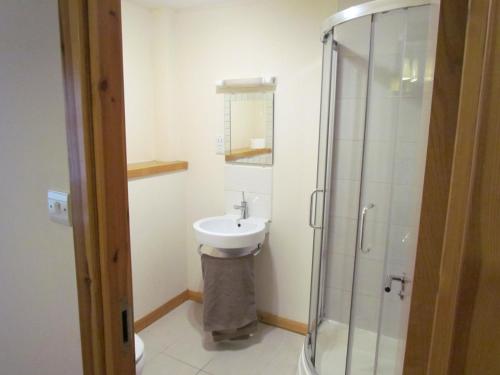 La salle de bains est pourvue d'un lavabo et d'une douche. dans l'établissement Farraline Court, à Inverness