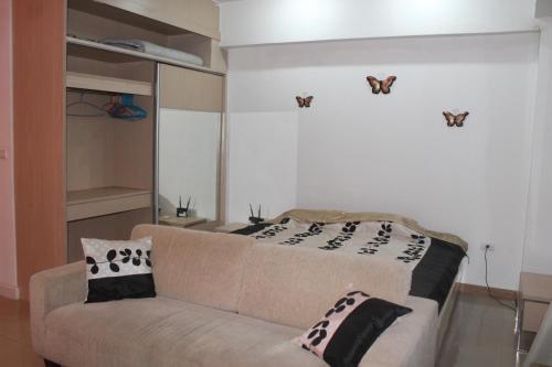 a living room with a couch and butterflies on the wall at Studio in Haven in Bangkok