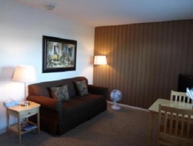 uma sala de estar com um sofá e uma mesa em Driftwood by the Sea Inn em Campbell River
