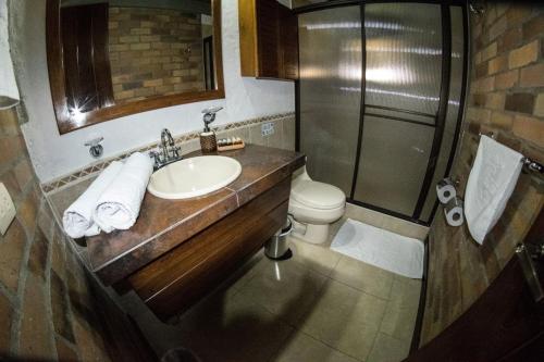 a bathroom with a sink and a shower and a toilet at Hotel Tata Premium in Pueblo Tapao