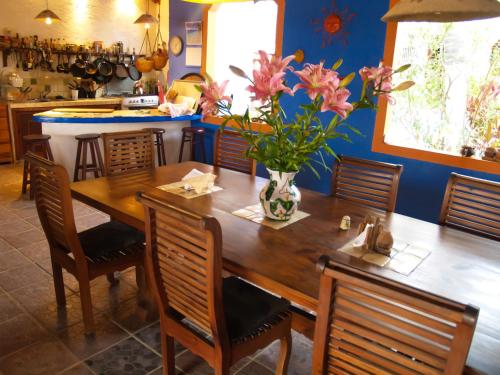 a dining room table with a vase of flowers on it at Hotel Gilda in Coyuca