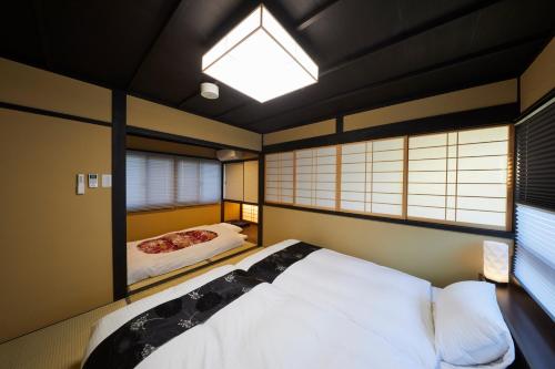 京都市にある鈴 五条壬生川 東 のベッドルーム1室(白いベッド1台、窓2つ付)