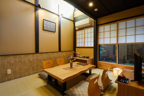 - une salle à manger avec une table et des chaises en bois dans l'établissement Rinn Gojomibugawa East, à Kyoto