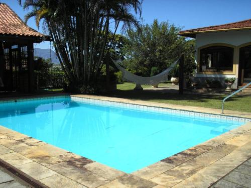 伊坦帕瓦的住宿－Suites em meio a Mata Atlântica，房屋前带吊床的游泳池