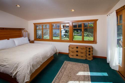 a bedroom with a bed and some windows at Mendocino View East in Mendocino