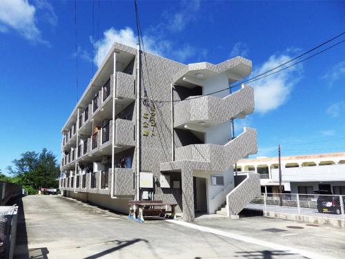 a white building with spiral stairs on the side of it at BIGJOY INN Hirokouji in Miyako-jima