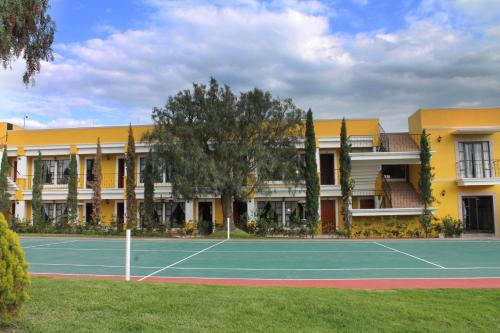 a tennis court in front of a building at Quinta Huizache in Santa María Nopaltepec