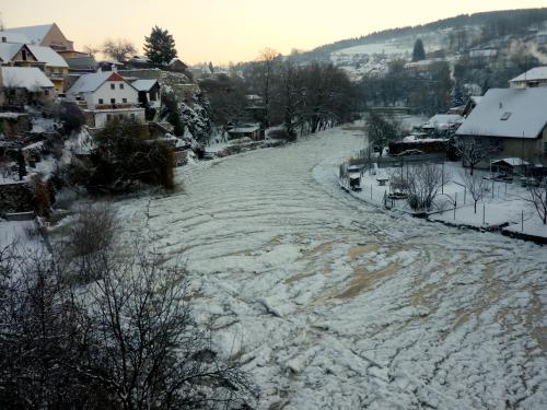 a road covered in snow in a town with houses at Pension Plešivecká 119 in Český Krumlov